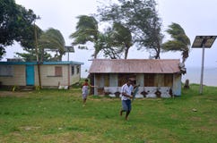 Fijianfolkkörning som får skyddet under en tropiska Cyclon arkivfoto Fijianfolkkörning som får skyddet under en tropiska Cyclon arkivfoto