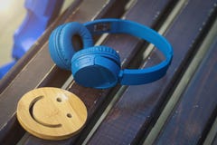 Fijne muziek voor perfecte stemming De draadloze hoofdtelefoons van blauwe kleur liggen op een donkere houten bank Een glimlach H royalty-vrije stock afbeeldingen Fijne muziek voor perfecte stemming De draadloze hoofdtelefoons van blauwe kleur liggen op een donkere houten bank Een glimlach H royalty-vrije stock afbeeldingen