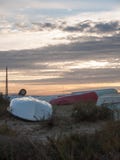 Fila del piano rovesciato dei crogioli di spiaggia su terra con il sole drammatico s stabilita fotografia stock Fila del piano rovesciato dei crogioli di spiaggia su terra con il sole drammatico s stabilita fotografia stock