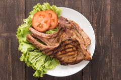 Filete asado a la parrilla con las verduras en un fondo de madera Fotografía de archivo libre de regalías