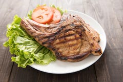 Filete asado a la parrilla con las verduras en un fondo de madera Imagenes de archivo