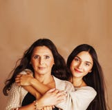 Filha consideravelmente adolescente bonito com a mãe madura que abraça, fim moreno acima dos mulato do tann, cores mornas da comp imagens de stock royalty free Filha consideravelmente adolescente bonito com a mãe madura que abraça, fim moreno acima dos mulato do tann, cores mornas da comp imagens de stock royalty free