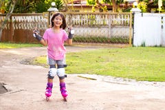 Fille asiatique de sourire jouant le roller à la maison Sport de loisirs images libres de droits Fille asiatique de sourire jouant le roller à la maison Sport de loisirs images libres de droits