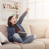 Fille avec l'instrument sur le divan à la maison photographie stock libre de droits Fille avec l'instrument sur le divan à la maison photographie stock libre de droits