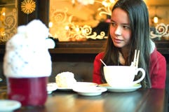 Fille avec une tasse de thé dans un café regardant loin Photo stock Fille avec une tasse de thé dans un café regardant loin Photo stock