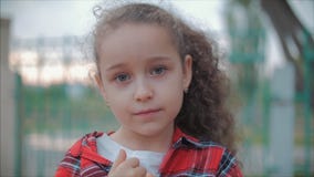 Fille caucasienne mignonne de portrait haut étroit petite regardant la caméra, appréciant le jour d'été chaud sur le coucher du s banque de vidéos Fille caucasienne mignonne de portrait haut étroit petite regardant la caméra, appréciant le jour d'été chaud sur le coucher du s banque de vidéos