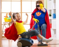 Fille d'enfant de super héros et sa mère faisant la blanchisserie ensemble dans le salon fille Familymiddle-âgée de femme et d'en image libre de droits Fille d'enfant de super héros et sa mère faisant la blanchisserie ensemble dans le salon fille Familymiddle-âgée de femme et d'en image libre de droits