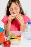 Fille d'école mangeant son sandwich emballé à déjeuner photo libre de droits Fille d'école mangeant son sandwich emballé à déjeuner photo libre de droits
