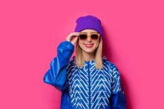 Fille dans la veste et le chapeau de sports 90s avec des lunettes de soleil images libres de droits Fille dans la veste et le chapeau de sports 90s avec des lunettes de soleil images libres de droits