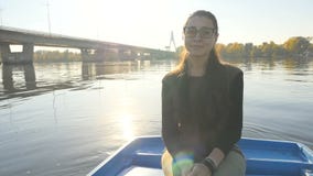Fille de charme dans un bateau sur le fond des rayons du soleil Un beau sourire sur son visage Bel endroit Mouvement lent banque de vidéos Fille de charme dans un bateau sur le fond des rayons du soleil Un beau sourire sur son visage Bel endroit Mouvement lent banque de vidéos