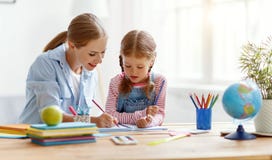 Fille de m?re et d'enfant faisant l'?criture et la lecture de devoirs ? la maison images libres de droits Fille de m?re et d'enfant faisant l'?criture et la lecture de devoirs ? la maison images libres de droits