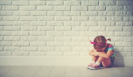 Fille de petit enfant pleurant et triste au sujet du mur de briques image libre de droits Fille de petit enfant pleurant et triste au sujet du mur de briques image libre de droits