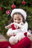 Fille de petit enfant étreignant son jouet pelucheux de renne près de Chris photos stock Fille de petit enfant étreignant son jouet pelucheux de renne près de Chris photos stock
