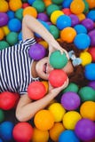 Fille de sourire mignonne dans la piscine de boule d'éponge photographie stock Fille de sourire mignonne dans la piscine de boule d'éponge photographie stock