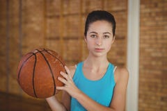 Fille déterminée tenant un basket-ball images libres de droits Fille déterminée tenant un basket-ball images libres de droits