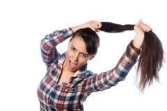 Fille gaie d'une manière amusante tenant ses longs cheveux dans la queue de cheval au-dessus du fond blanc images stock Fille gaie d'une manière amusante tenant ses longs cheveux dans la queue de cheval au-dessus du fond blanc images stock