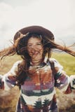 Fille heureuse de hippie de voyageur avec les cheveux venteux souriant, o debout images libres de droits Fille heureuse de hippie de voyageur avec les cheveux venteux souriant, o debout images libres de droits