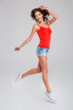 Fille inspirée de sourire heureuse dans le saut photographie stock libre de droits Fille inspirée de sourire heureuse dans le saut photographie stock libre de droits