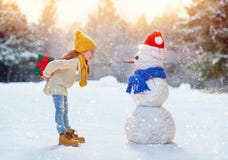 Fille jouant avec un bonhomme de neige photo libre de droits Fille jouant avec un bonhomme de neige photo libre de droits