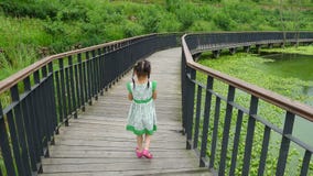 Fille marchant sur la passerelle en bois Photographie stock Fille marchant sur la passerelle en bois Photographie stock