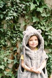 Fille mignonne d'enfant en bas âge dans le manteau pelucheux jouant près du mur avec le lierre image stock Fille mignonne d'enfant en bas âge dans le manteau pelucheux jouant près du mur avec le lierre image stock
