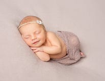 Fille nouveau-née de sommeil de sourire couverte de châle photographie stock libre de droits Fille nouveau-née de sommeil de sourire couverte de châle photographie stock libre de droits
