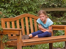 Fille obtenant fâchée sur le banc de stationnement image libre de droits Fille obtenant fâchée sur le banc de stationnement image libre de droits