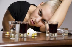 Fille prise une overdose entourée avec les drogues et l'alcool photo libre de droits Fille prise une overdose entourée avec les drogues et l'alcool photo libre de droits