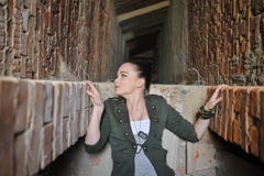 Fille près du mur de briques dans le style militaire photo stock Fille près du mur de briques dans le style militaire photo stock