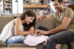 Fille s'asseyant sur des clous du ` s de Sofa At Home Painting Father image stock Fille s'asseyant sur des clous du ` s de Sofa At Home Painting Father image stock