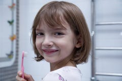 Fille se brossant les dents dans la salle de bains image stock Fille se brossant les dents dans la salle de bains image stock
