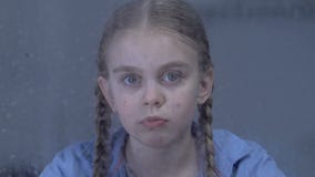 Fille seule regardant à la caméra par la fenêtre pluvieuse, douleur abandonnée d'enfant clips vidéos Fille seule regardant à la caméra par la fenêtre pluvieuse, douleur abandonnée d'enfant clips vidéos