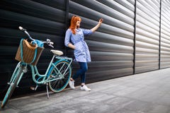 Fille urbaine prenant le selfie dans la ville près du vélo photographie stock libre de droits Fille urbaine prenant le selfie dans la ville près du vélo photographie stock libre de droits
