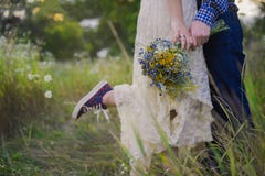 Fille à la mode de jeunes couples sains dans un type de robe de mariage dans une chemise de plaid se tenant avec un bouquet des f Photo stock Fille à la mode de jeunes couples sains dans un type de robe de mariage dans une chemise de plaid se tenant avec un bouquet des f Photo stock