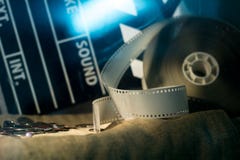 Filme do negativo de filme da válvula e do vídeo do cinema em um pano áspero fotografia de stock Filme do negativo de filme da válvula e do vídeo do cinema em um pano áspero fotografia de stock
