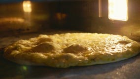 A filtração do close-up disparou do cozimento no forno, movimento lento da pizza imagem de stock A filtração do close-up disparou do cozimento no forno, movimento lento da pizza imagem de stock