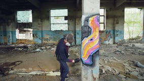 Filtri il colpo dell'artista adulto dei graffiti dell'uomo nella maschera di protezione protettiva e dei guanti che dipingono alt stock footage Filtri il colpo dell'artista adulto dei graffiti dell'uomo nella maschera di protezione protettiva e dei guanti che dipingono alt stock footage