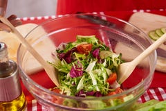 Fim acima A dona de casa está agitando a salada na cozinha foto de stock Fim acima A dona de casa está agitando a salada na cozinha foto de stock