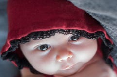 Fim da cara do bebê acima, com os olhos bonitos grandes Recém-nascido em um c vermelho foto de stock royalty free Fim da cara do bebê acima, com os olhos bonitos grandes Recém-nascido em um c vermelho foto de stock royalty free