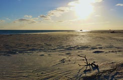 Fim da tarde na praia larga abandonada com o barco no oceano imagem de stock royalty free Fim da tarde na praia larga abandonada com o barco no oceano imagem de stock royalty free