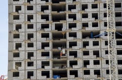 Fim do canteiro de obras acima Nos assoalhos médios, os trabalhadores descarregam materiais de construção fotos de stock Fim do canteiro de obras acima Nos assoalhos médios, os trabalhadores descarregam materiais de construção fotos de stock