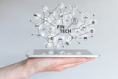 Fin Tech and mobile computing concept. Hand holding tablet in front of grey background stock images Fin Tech and mobile computing concept. Hand holding tablet in front of grey background stock images