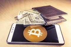 Financial concept with a wallet with US dollars, USB cable and smartphone with bitcoin logo stock photos Financial concept with a wallet with US dollars, USB cable and smartphone with bitcoin logo stock photos