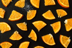 Finely sliced tangerines on a wet black background stock photography Finely sliced tangerines on a wet black background stock photography