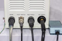 Fio elétrico conectado na caixa de controle da máquina de soldadura do Tig e do interruptor de pé na tabela na fábrica imagem de stock Fio elétrico conectado na caixa de controle da máquina de soldadura do Tig e do interruptor de pé na tabela na fábrica imagem de stock
