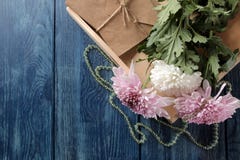 Fiori di autunno del crisantemo con le perle e le lettere su una tavola blu scuro con un posto per l'iscrizione fotografia stock libera da diritti Fiori di autunno del crisantemo con le perle e le lettere su una tavola blu scuro con un posto per l'iscrizione fotografia stock libera da diritti