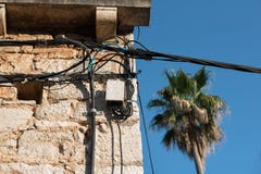 Fios elétricos unidos em uma casa de pedra velha Edifício redondo Transmissão da eletricidade Ampola na construção Ligh da rua imagens de stock Fios elétricos unidos em uma casa de pedra velha Edifício redondo Transmissão da eletricidade Ampola na construção Ligh da rua imagens de stock