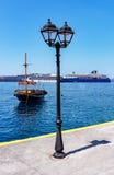 Fira, Santorini/Греция - 05-25-2014: 2 больших туристического судна и старой шлюпка в малой гавани Fira, Santorini, Греции стоковое фото rf Fira, Santorini/Греция - 05-25-2014: 2 больших туристического судна и старой шлюпка в малой гавани Fira, Santorini, Греции стоковое фото rf