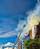 Firemen on a ladder extinguishing fire Royalty Free Stock Image Firemen on a ladder extinguishing fire Royalty Free Stock Image