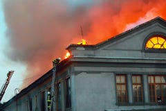 Firefighters on the roof of a house that is on fire stock photos Firefighters on the roof of a house that is on fire stock photos